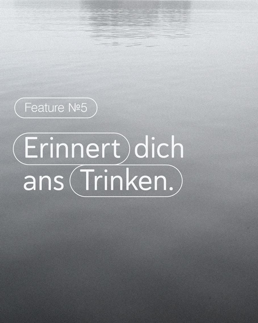 Mitarbeiterin sitzt am Schreibtisch und arbeitet am Laptop. Auf dem Schreibtisch steht ein Glas Wasser und ein Apfel. Daneben steht ein Isa Gesundheitscoach, welcher durch Sensorik die Körperhaltung der Frau analysiert. dies wird durch Punkte und Linien auf dem Körper der Frau angedeutet.