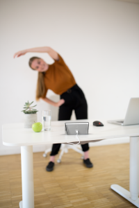 Junger Mann arbeitet am Schreibtisch und schaut dabei auf seine Isa.